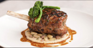 Huge perfectly cooked Pork Chop over Bed of greens