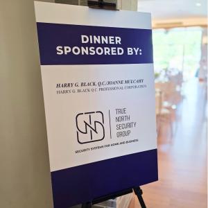 Dinner Sponsor stand at YRPA 2025 golf tournament with TNSG logo