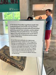 A close-up view of the museum description for "The Flowers Personified" by J.J. Grandville, the inspiration piece for Althea Wiles' 2025 Art in Bloom floral installation. Photo courtesy of ©AltheaWiles.