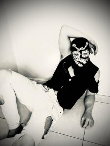caelthorne is posing with his face painted in a high fashion style photo all in black and white to provoke conversation and communicate a message caelthorne almost looks like the joker with the way his face is painted in this photo.