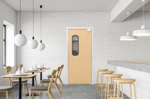 A wood grain door in a cafe with a ADA vision lite kit.