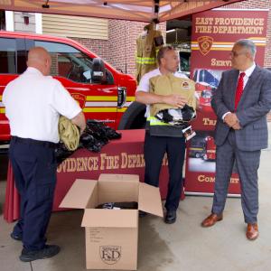 East Providence Fire Chief Michael Carey, East Providence Fire Department Battalion Chief Joe daSilva and East Providence Mayor Roberto DaSilva pass out new non-PFAS turnout gear to East Providence firefighters.