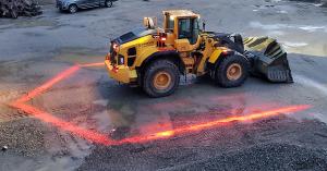 Image depicts the PerimeterSAFE Zone Lighting in use on a loader with the red zone lights visible on the ground surrounding the loader.