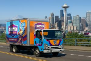Trusted Plumbing & Heating work truck driving with the Space Needle in the background.