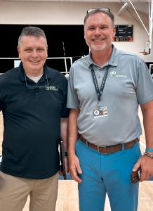 Jim Boyte and Dr. Seth Powers from Active Defender smiling at the camera inside a school gymnasium during the School Safety Summit in Pinehurst, NC