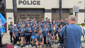 San Fernando police officers and community members pose with the Special Olympics torch in front of the San Fernando Police Station during the 2025 Law Enforcement Torch Run.