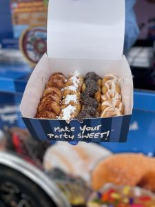 A box of 24 mini donuts made from a DonutNV food truck and topped with sugar toppings