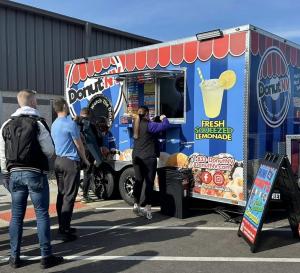 Photo of a DonutNV donut trailer at an event with customers waiting in line to order