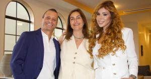 Gabriel Bar, Shani Bar, and Bella Cohen, co-founders of Be Belong, seated together in a modern office lobby with a building exterior visible in the background, symbolizing leadership in AI-driven multifamily housing innovation.