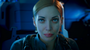 Close-up of a female animated character with pale skin, blue eyes, and reddish-brown hair pulled back, wearing a futuristic gray uniform with harness straps. The character appears focused and calm, seated in a sci-fi spacecraft interior with cool blue lig