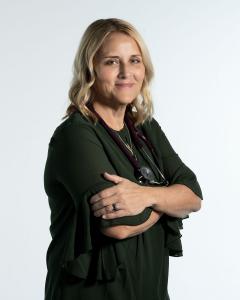 Professional portrait of Carrie Oram, holistic nurse practitioner and contributing author to the international #1 bestselling book Whispers of the Soul: Stories of Resilience, Awakening, and the Power of Healing from Within. She stands confidently in a da