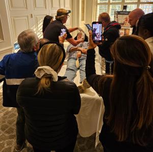 Attendees gathered around patient table observing injectable procedure.
