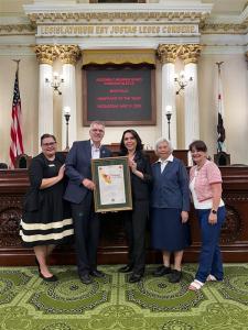 Five people stand smiling at the California State Capitol as Maryvale President Steve Gunther and Assemblymember Blanca Rubio hold a framed Nonprofit of the Year award certificate