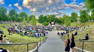 Young and old filter into the amphitheater as the orchestra performs
