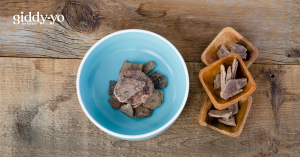 Ceremonial Cacao Paste- a few pieces in a blue ceramic bowl and 3 small wooden bowls to the right