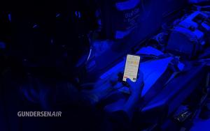 Photo of a GundersenAIR crew member en route to an emergency viewing OneDose® on a mobile device.