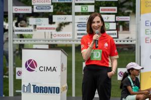 Janice Farrell Jones, SVP of Everyday Banking, Savings and Investing at TD Bank Group, speaks at a podium during the CIMA Mayor’s Trophy Cricket opening ceremony.