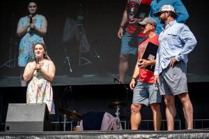 Carry The Load Ambassadors Michael Flowers and Cody Bandars award a scholarship to one of seven 2025 recipients at the Dallas Memorial March.