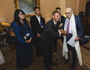 Senate Minority Leader Chuck Schumer receives a traditional Tibetan white scarf (khata) from members of the Tibetan community during a Capitol Hill visit advocating for human rights and the preservation of Tibetan culture.