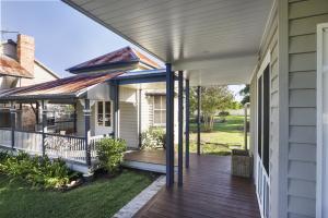 Exterior of Gregor’s Creek home showing new Hamptons-style farmhouse connected to restored historic structures, designed by Dion Seminara Architecture.