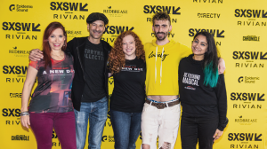 Ferryman Collective team members Deirdre V. Lyons, Stephen Butchko, Whitton Frank, Christopher Lane Davis, and Tanvi Agrawal smiling together in front of the SXSW XR Experience 2025 step-and-repeat backdrop.