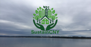 The Sustain CNY Logo over a photo of Onondaga Lake on a rainy day