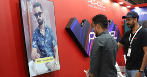 People interacting with Pickcel's gender-based content triggering signage at In-Store Asia event