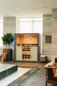 Modern HaloSauna™ unit installed in luxury spa near indoor pool at Four Seasons Hotel Toronto, featuring wood interior and glass doors.