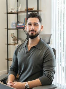 Dr. Robert Morales sitting in his office wearing a dark grey shirt