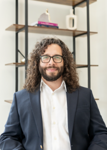 Dr. Jonathan Rojas wearing a navy blazer with a white shirt