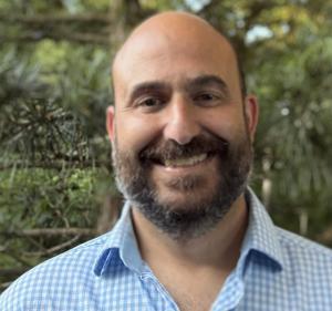 Peter Anselmi, Business Development Manager at Blue Orchid Marketing, smiling outdoors in a blue checkered shirt.