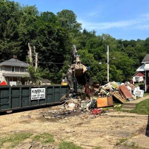 Heavy Equipment Loads Waste and Debris into a Kimble Donated Roll Off Dumpster