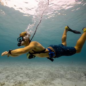 Diver using BLU3 Nomad Mini tankless dive system for shallow water exploration and recreational underwater diving.