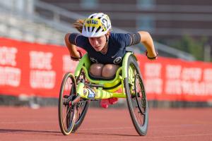 An athlete in a sports wheelchair races on the track