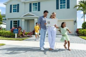 Happy Family Stands Outside Model Home Built By Lennar Homes