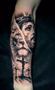 Detailed forearm tattoo showing Jesus with a crown of thorns, a realistic lion face, and three crucifixes below, created in black and grey ink.