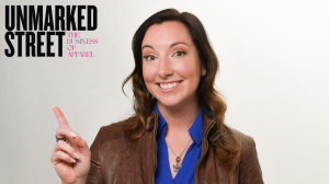 Rachel Erickson, founder, smiling and pointing at Unmarked Street, The Business of Apparel, logo