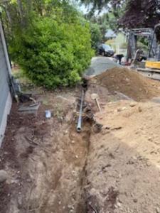 Using the mini excavator to dig out around the home for the electrical line