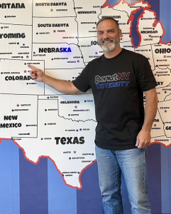 A DonutNV franchise owner points to a map showing his territory location in Fort Collins, Colorado