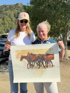 a female arena polo player poses with another woman and her lithograph award