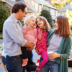 Two parents and their daughters sharing a joyful moment, reflecting community-focused values of health care sharing ministries.