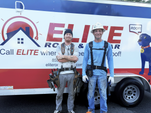 Two Elite Roof and Solar crew members, Hunter Jackson and Chad Thomas, standing in front of a branded company trailer. Both are wearing work gear and tool belts, ready for a seamless gutter installation.