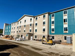 Rear view of the under-construction WoodSpring Suites Santee hotel by Level 3 Construction, highlighting progress on this ground-up hospitality project for repeat client Gold Coast Premier Properties. With the exterior facade now complete, the company shi