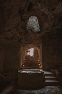 Bathtub in a cavernous space at Portal 62, with stone walls and stairs leading down from the rear patio.