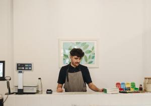 Man standing behind food retail counter with a plan background