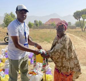 Father Alphonsus Afina distributing food aid to victims of Boko Haram terror.