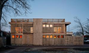 Twilight image with windows glowing orange of an artistic alley house framed with BamCore panels in Washington D.C.