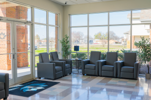 spacious indoor lobby with comfortable chairs and floor to ceiling windows