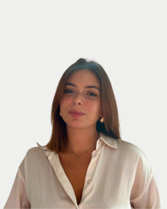 Portrait of Giusy Versace, a branding consultant with shoulder-length brown hair, wearing a light blouse and necklace, looking confidently at the camera.