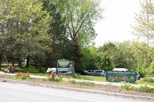 American Meadows headquarters in spring, with a large Reduce Your Lawn Day banner, a tiller, and an American flag visible. The team is preparing to convert roadside turf into pollinator habitat, promoting sustainable landscaping and public awareness.